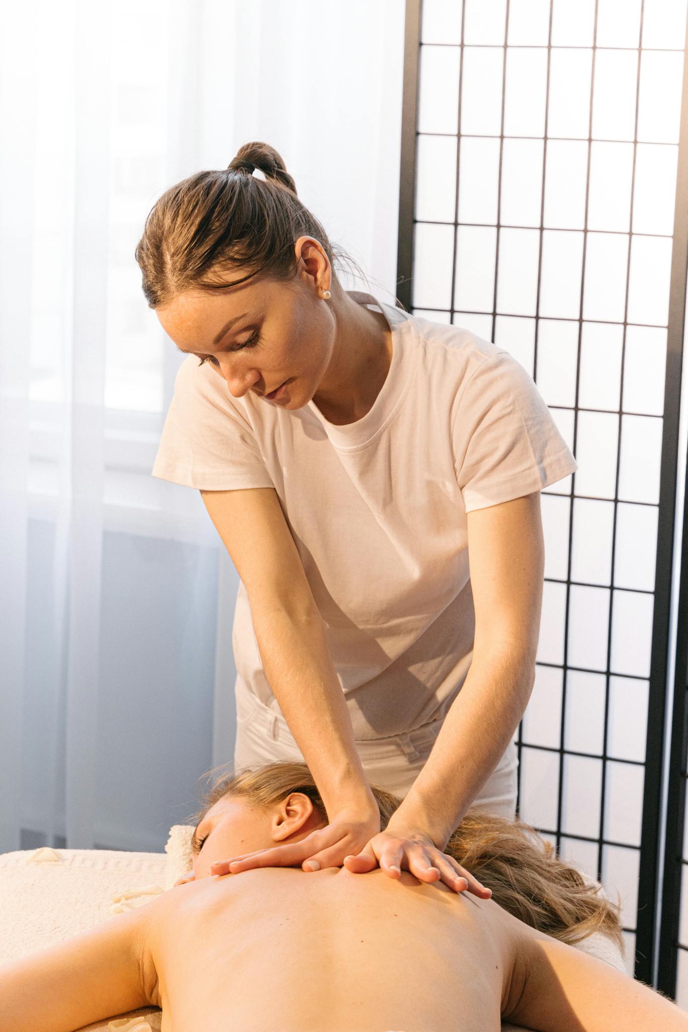 Experienced masseuse providing a relaxing back massage in a tranquil spa setting.