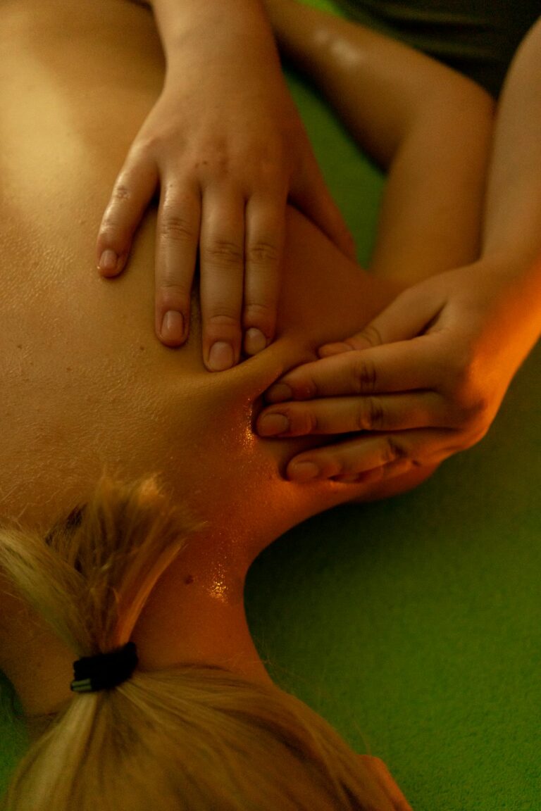 From above of anonymous slim female with short hair lying on stomach and resting during massage session
